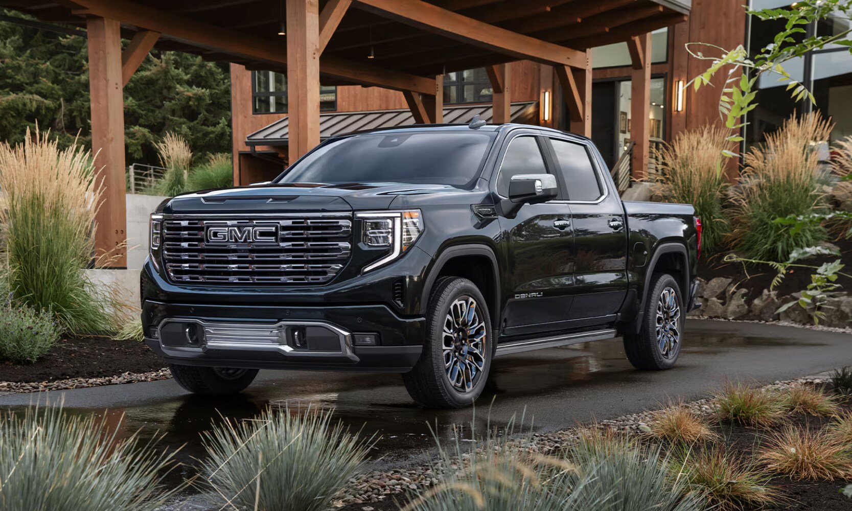 2026%20GMC%20Sierra%201500%20Denali%20Ultimate%20-%20Octane%20GMC%20of%20Santa%20Fe.png Exterior front angle image of a black 2026 GMC Sierra 1500 Denali Ultimate parked in a home's driveway in a tropical setting