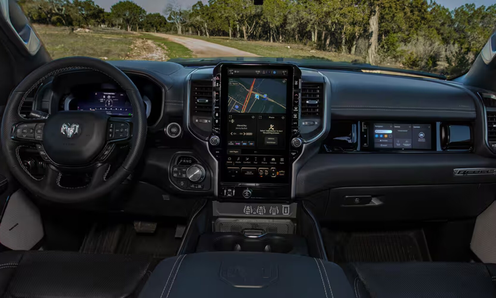 2025 GMC Sierra 1500 vs. 2025 RAM 1500 - 2025 RAM 1500 Interior - Octane GMC of Santa Fe.jpg Interior image of a 2025 RAM 1500 front seating area and infotainment system with park landscape views