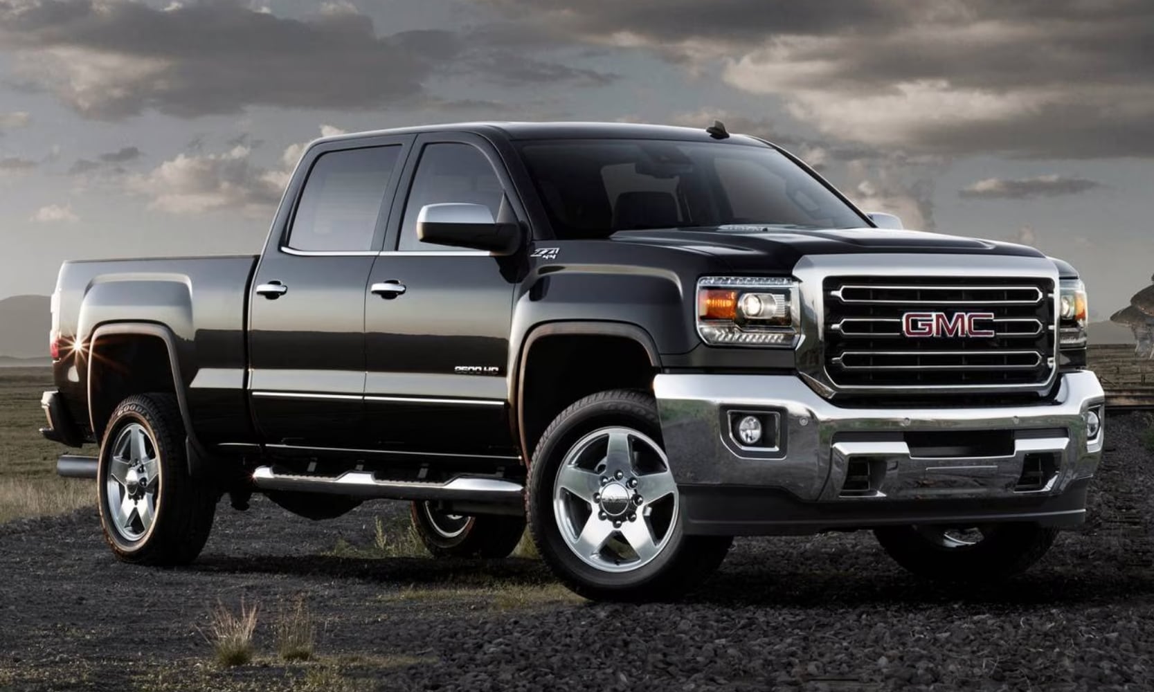 photo of a black 2016 GMC Sierra 2500 HD SLT Truck on a rocky road on a cloudy day