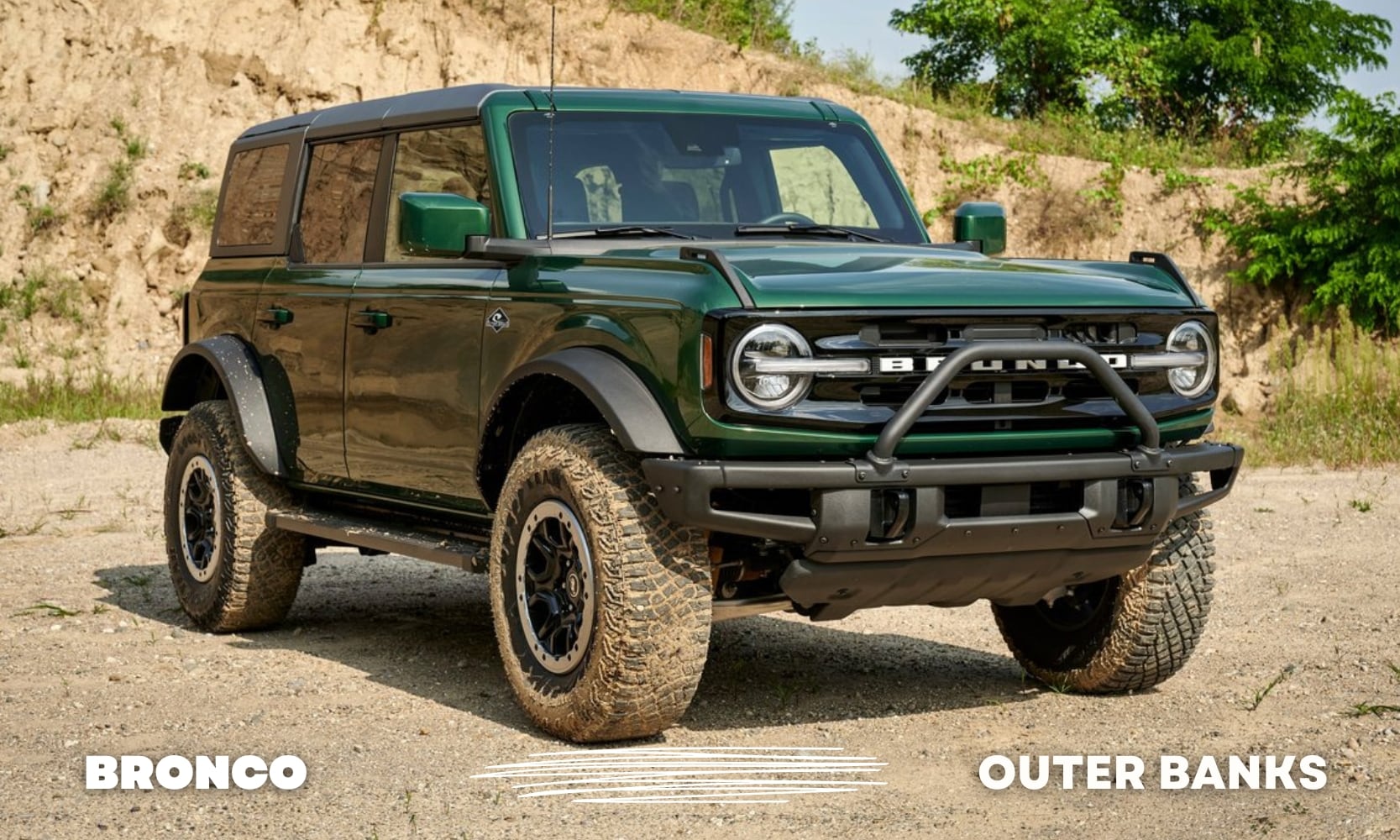 Front passenger side of a green Ford Bronco Outer Banks model parked on a rocky path with mud on the tires