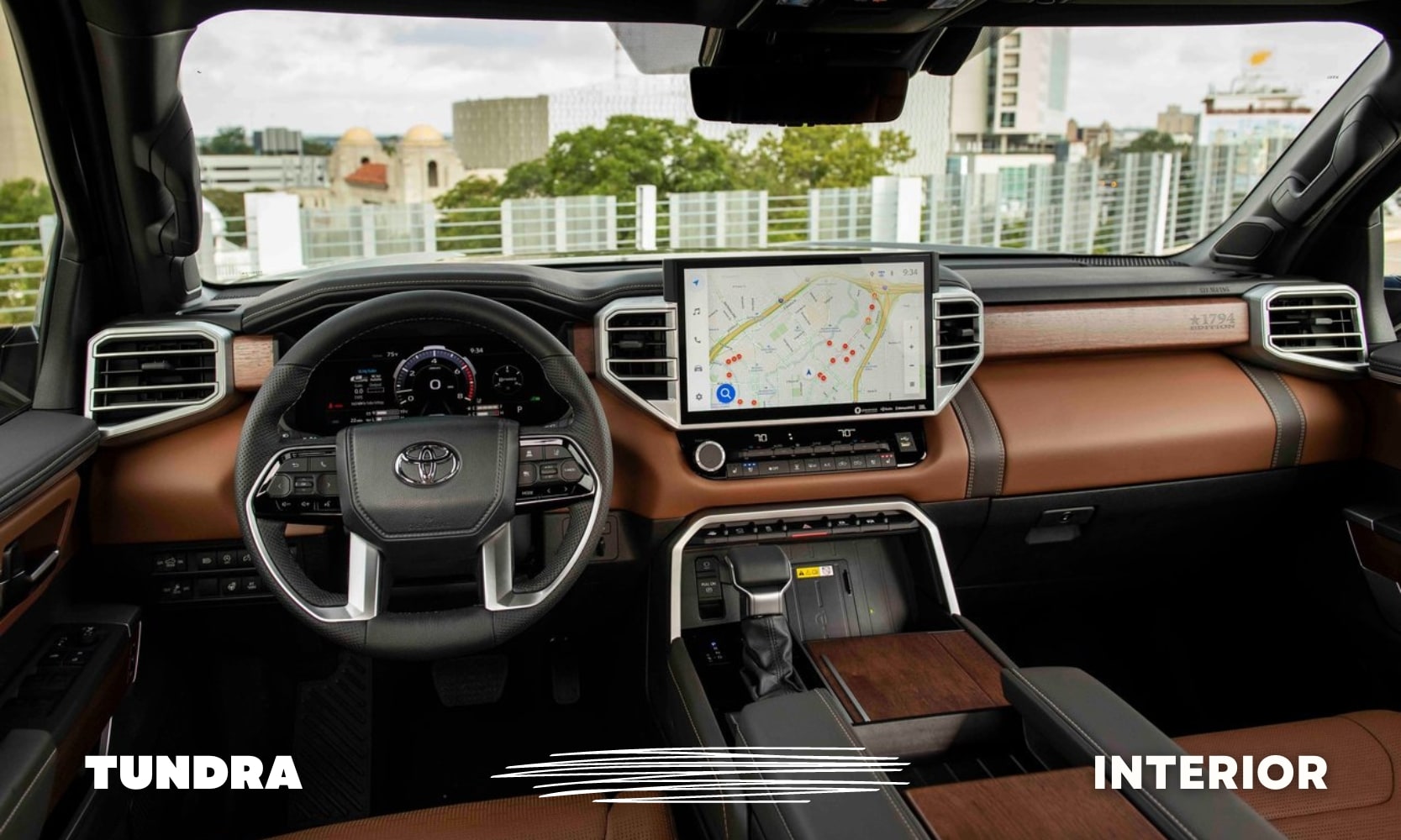 Front interior cabin view inside a used Toyota Tundra 1794 Edition truck with dark brown leather and wood accents throughout