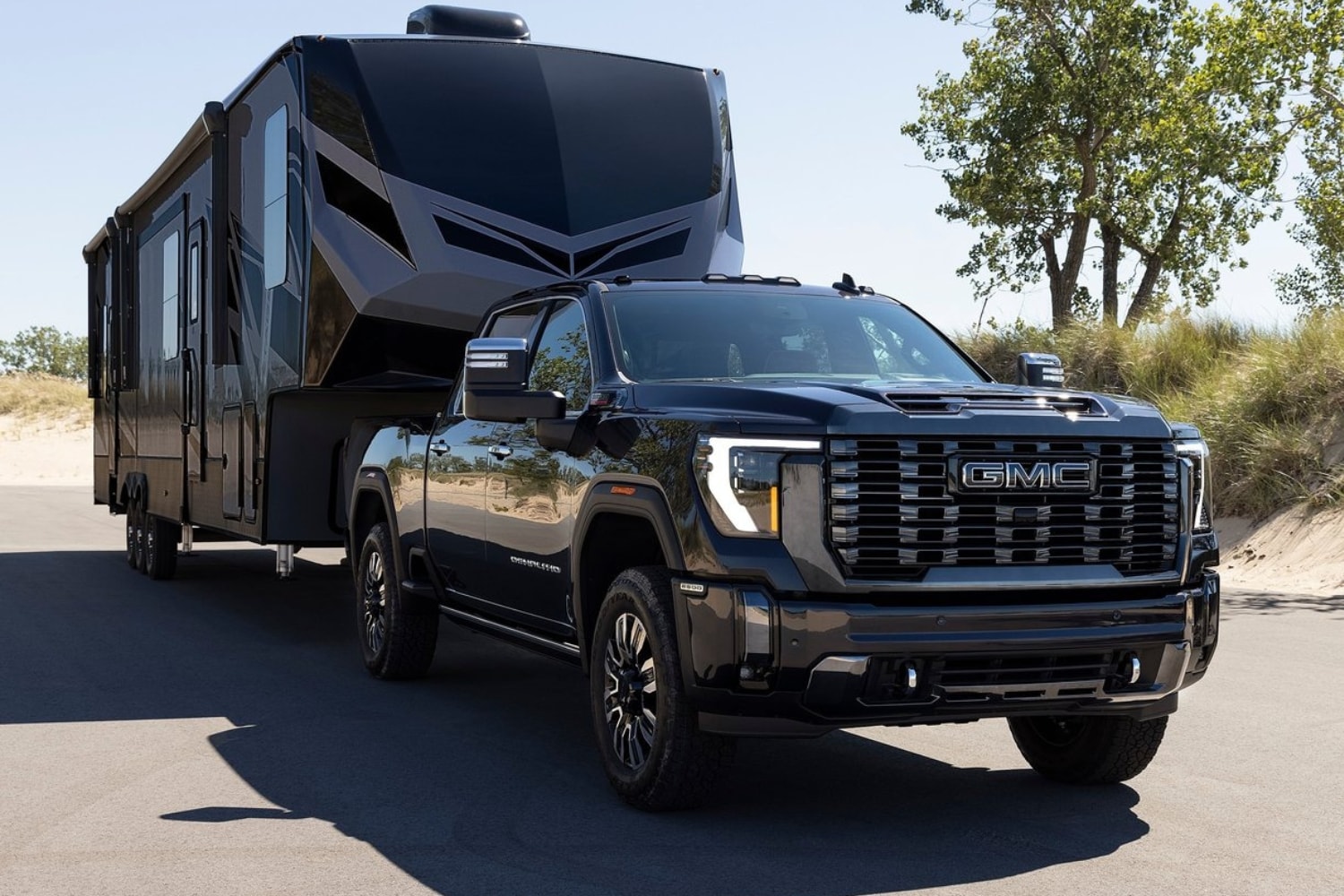 New 2024 GMC Sierra HD Towing Capacity Comparison - Octane GMC of Santa Fe.jpg Image of the 2024 GMC Sierra HD Denali Ultimate truck towing a large camper trailer with ease