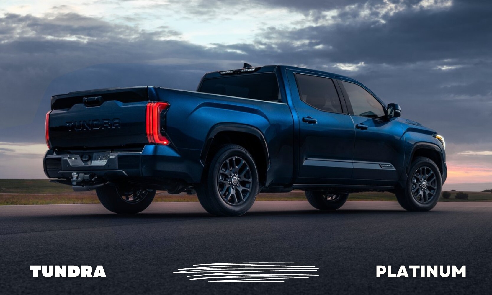 Rear ground level view of a blue used Toyota Tundra Platinum truck parked on the side of an open road at sunset on a cloudy day