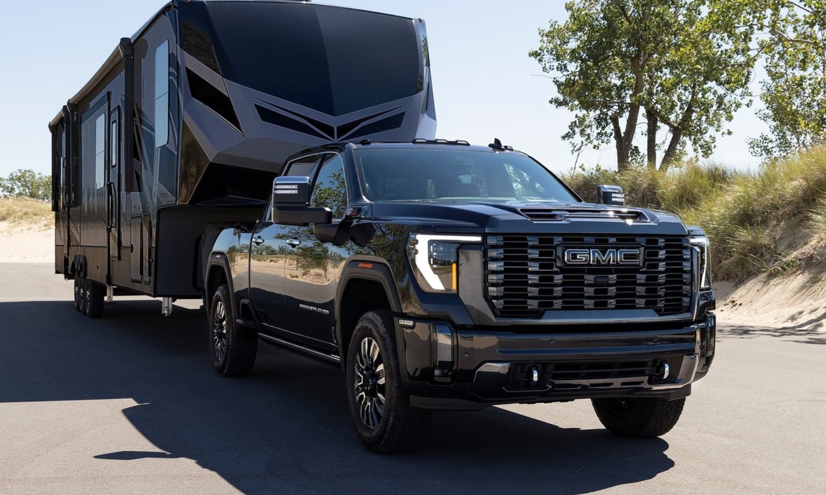 a 2024 GMC Sierra 2500 HD Denali Ultimate truck towing a large camper with gooseneck towing