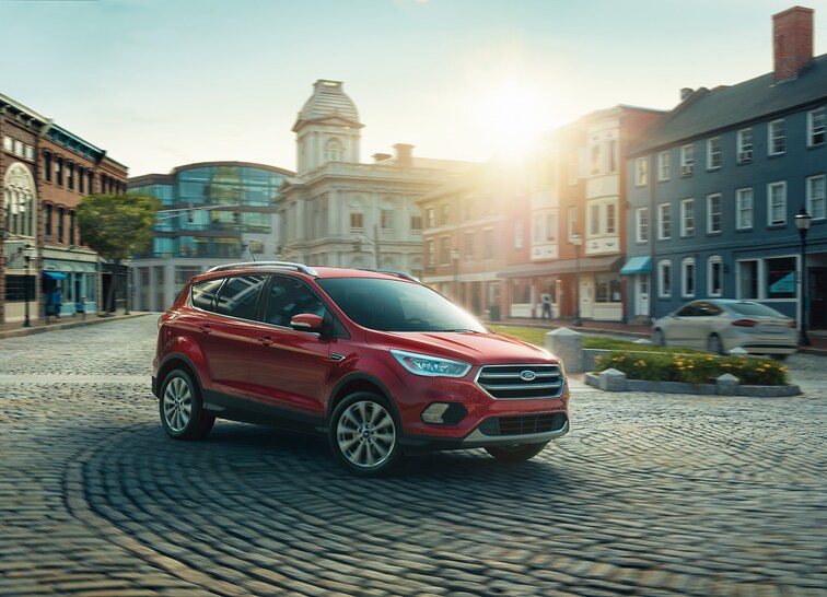 2018-Ford Escape-Titanium- SUV-L02 (2).png red Ford Escape SUV driving around a cobblestone roundabout