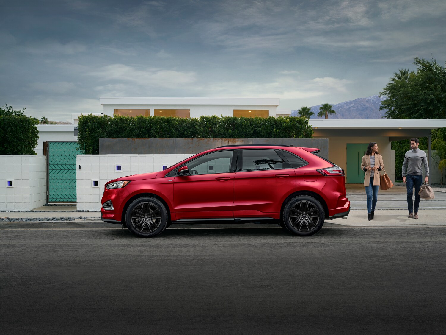 2021-Ford-Edge-ST-SUV-L06.png red Ford Edge SUV parked in front of a modern home