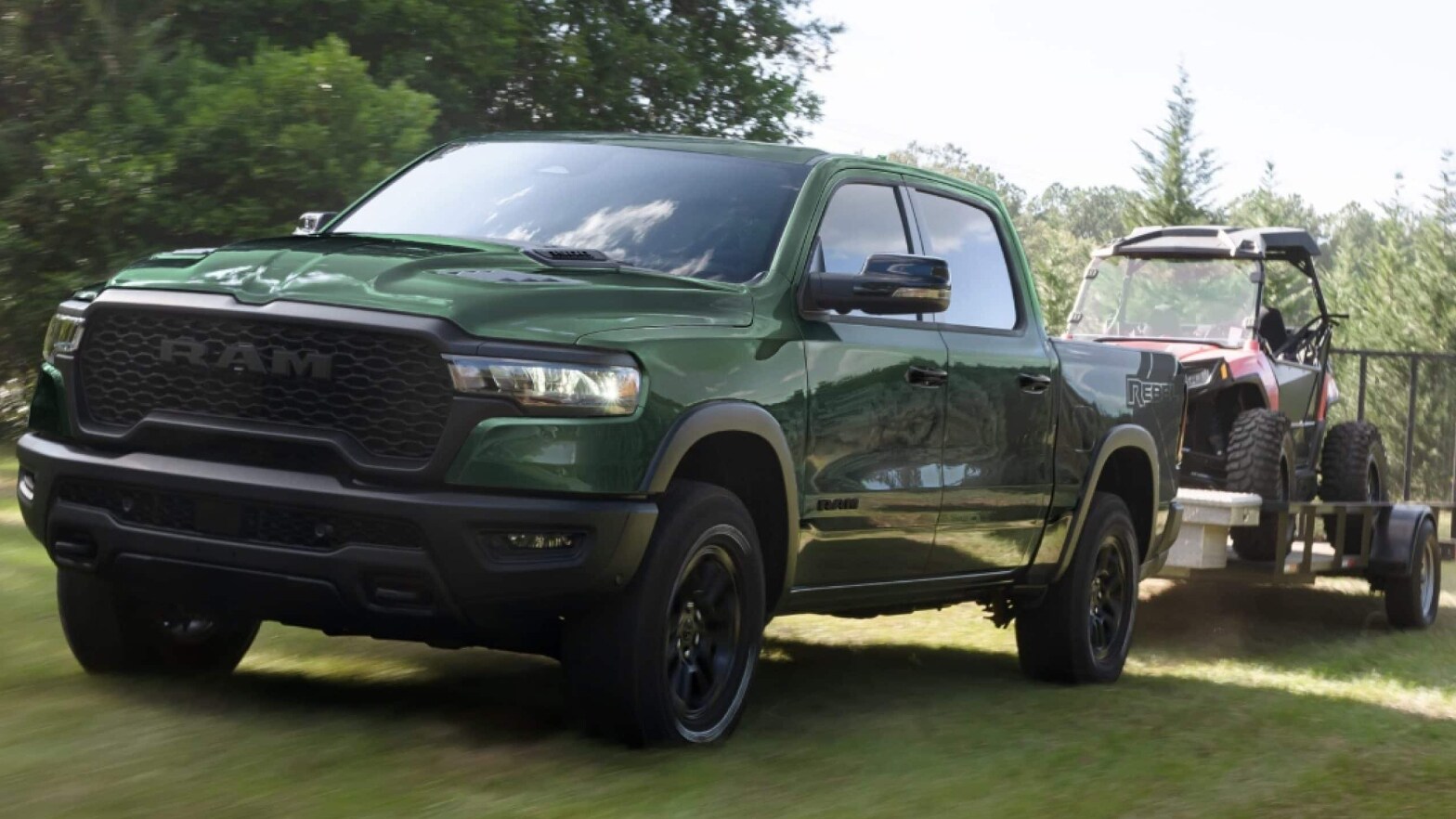 A green RAM 1500 towing a red golf cart over a grassy field.