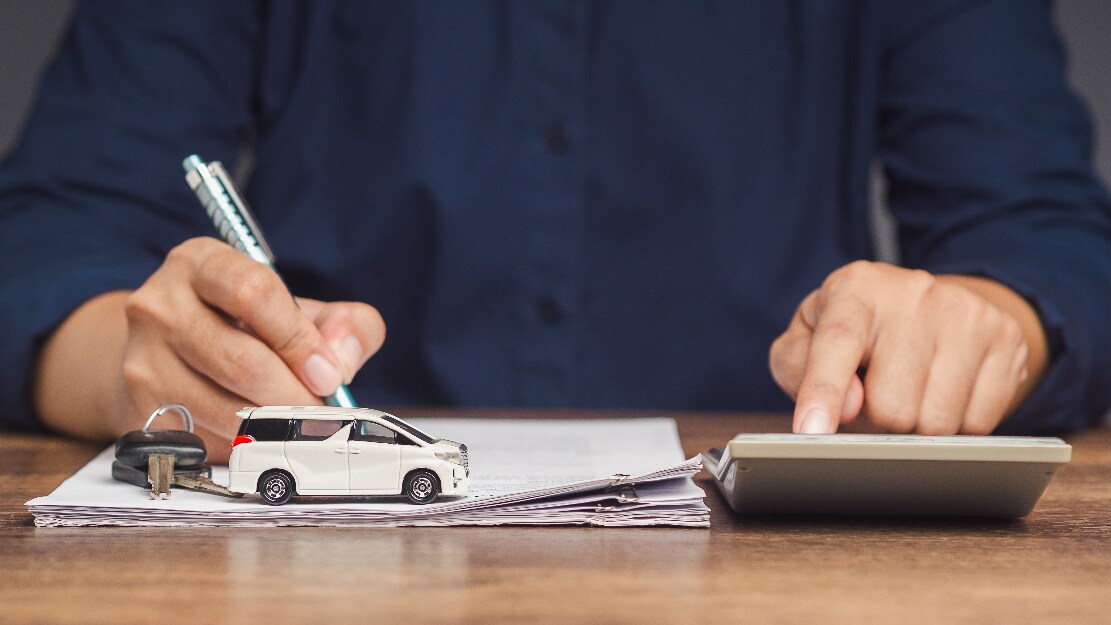 A man signing a car loan agreement.