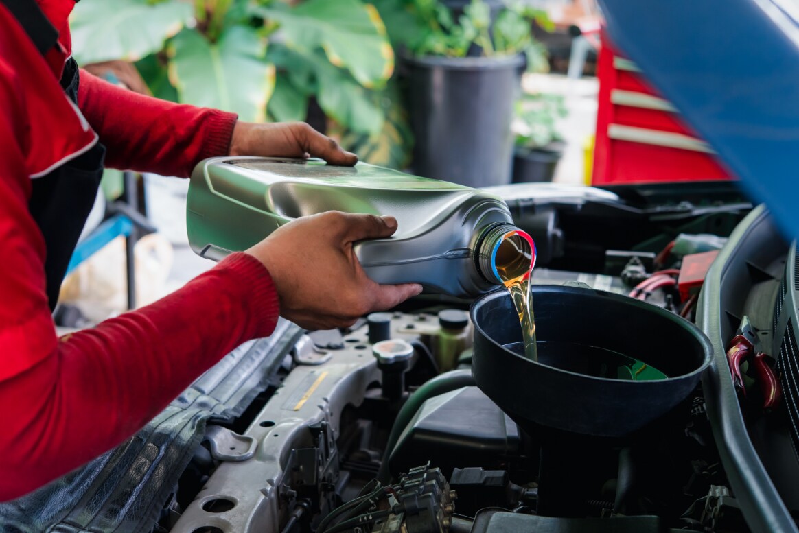 A vehicle receiving an oil change by a technician.