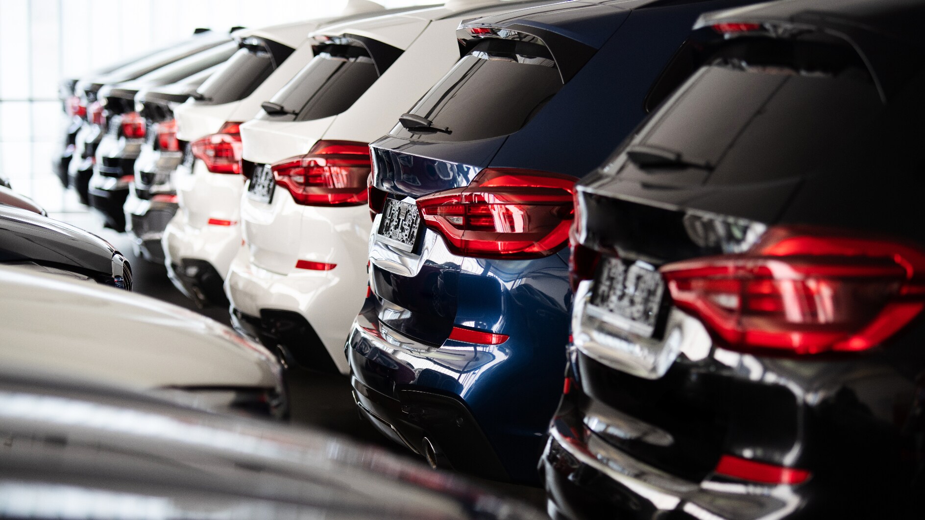 A row of cars on the interior of a dealership.