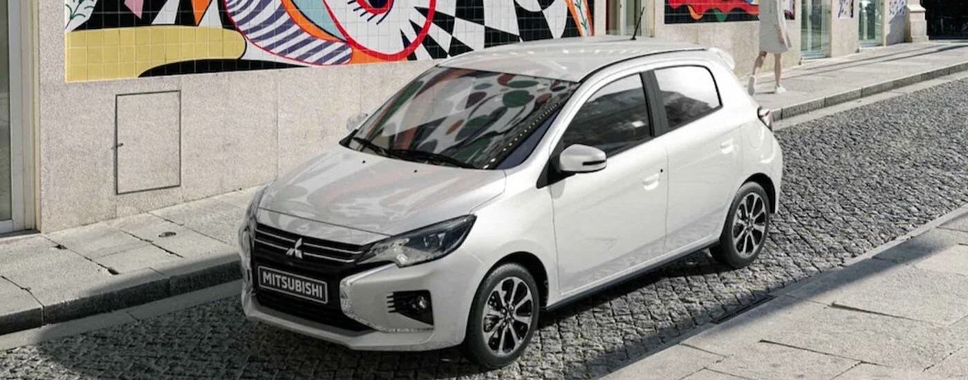 2024 Mitsubishi Mirage - White.jpg A white 2024 Mitsubishi Mirage is shown parked near a city curb.