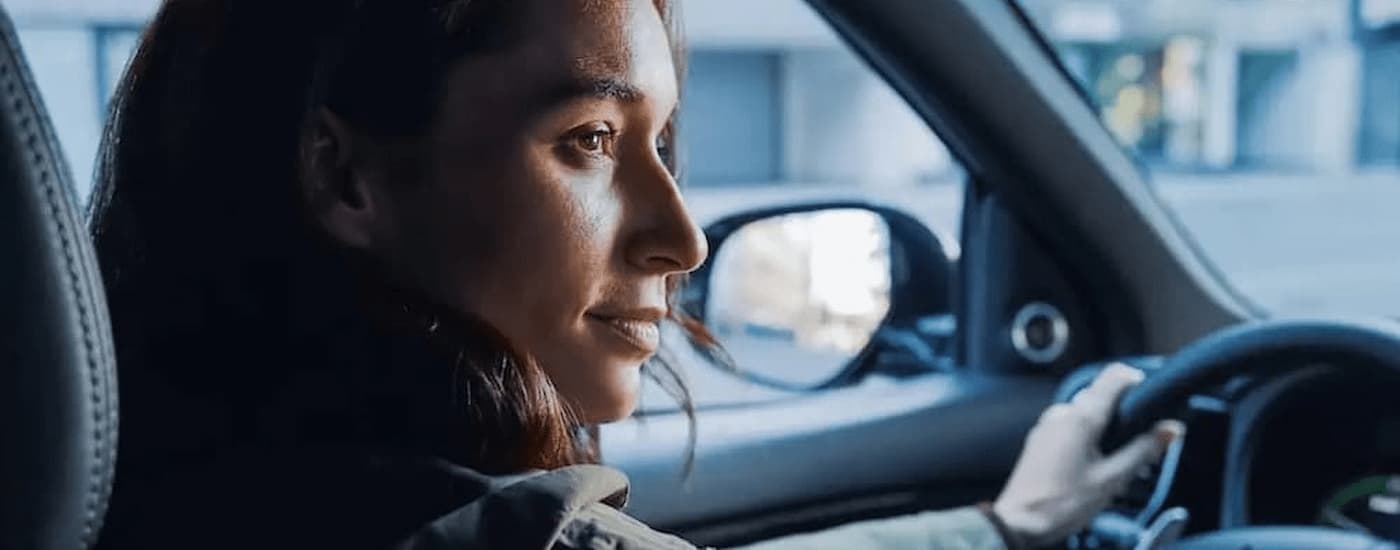 Mitsubishi Outlander PHEV for Sale - 2022 Mitsubishi Outlander PHEV - Woman Driving.jpg A woman driving a 2022 Mitsubishi Outlander PHEV on a city road.