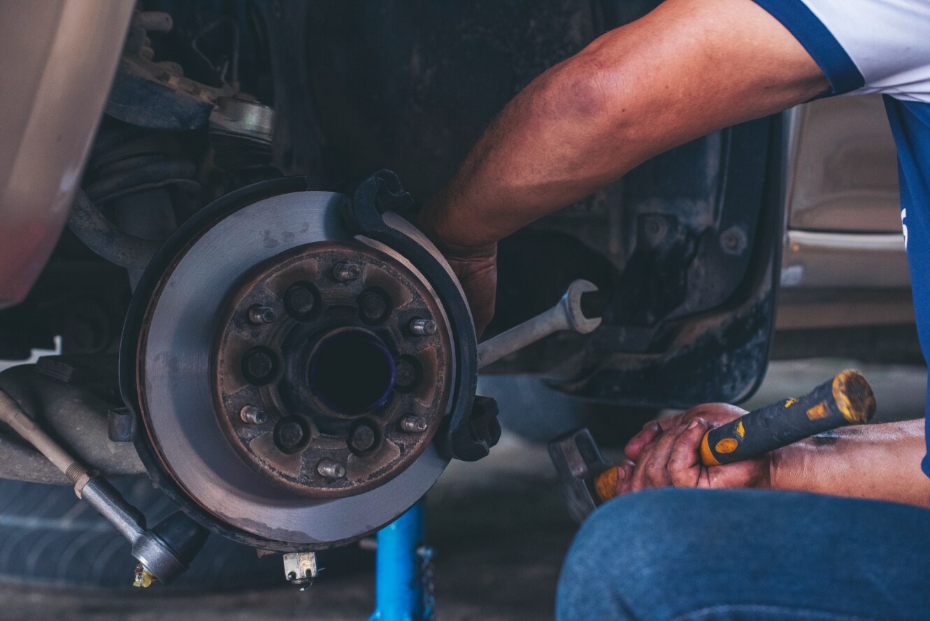 An engineer working on a vehicle's wheel.