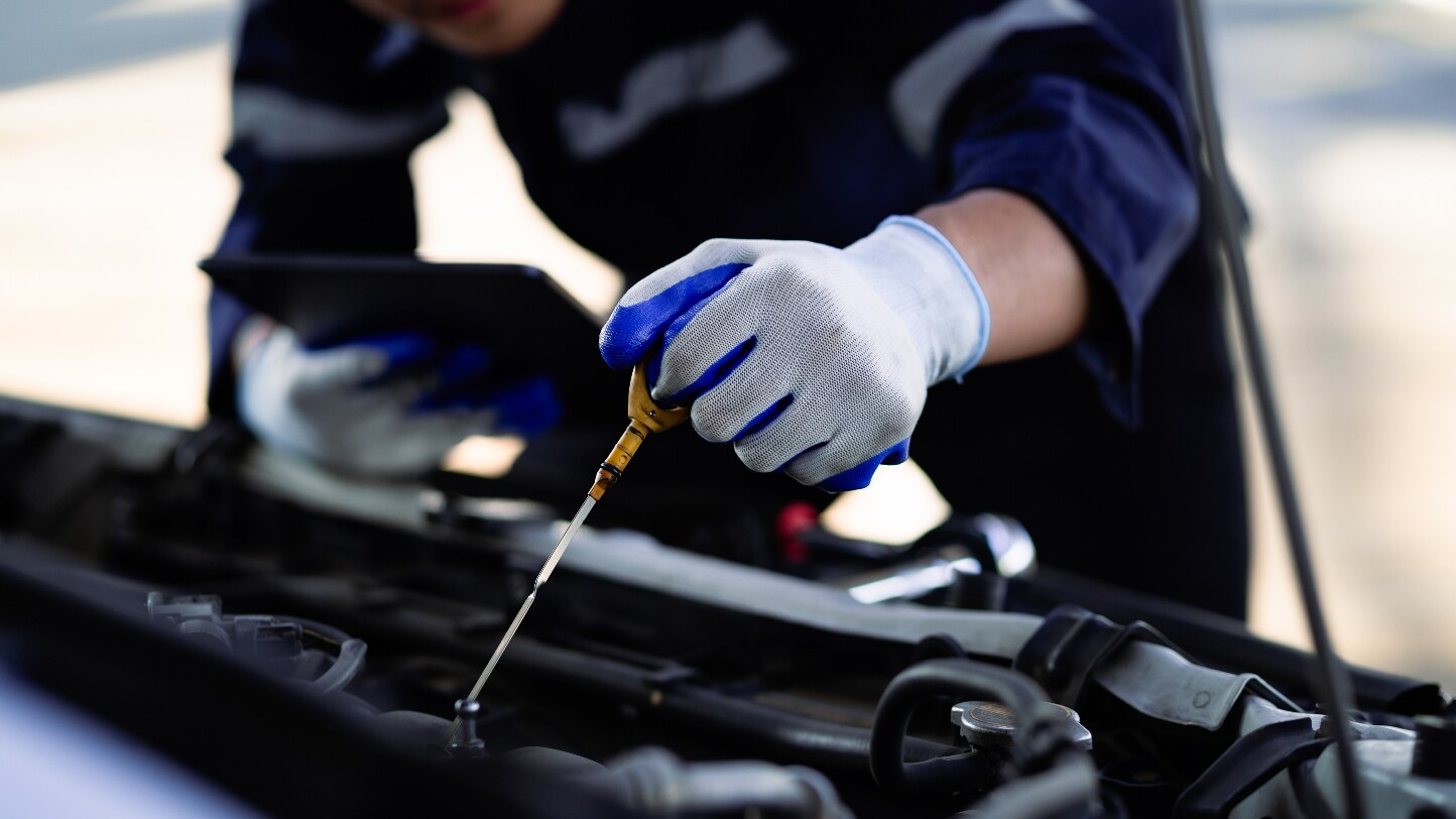 A mechanic performing maintenance on a a vehicle's engine.