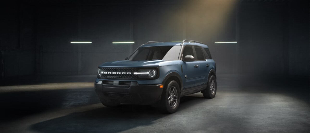 A blue Ford Bronco Sport in a dimly lit warehouse.
