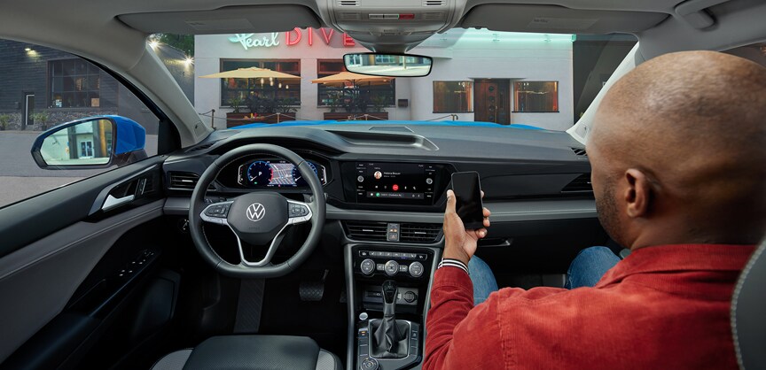 Performance features of the 2022 Taos at West Broad Volkswagen of Richmond | Man siting in passenger seat checking out interior