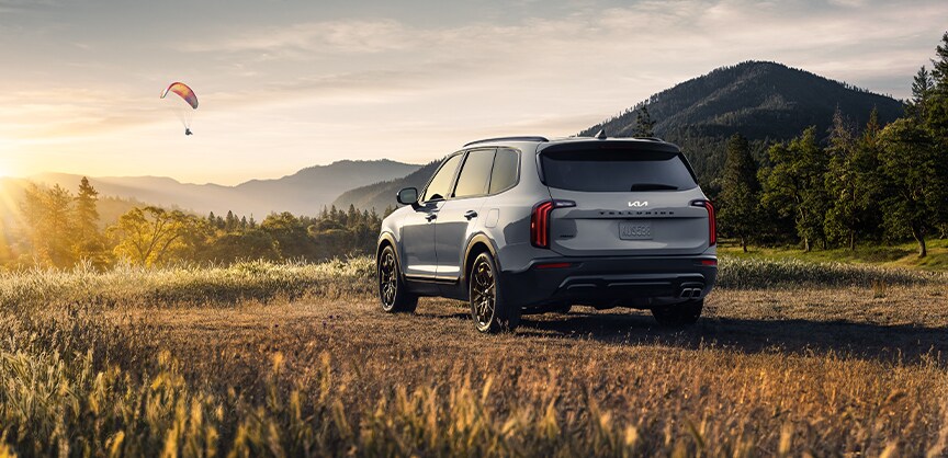 Performance features of the 2022 Telluride at West Broad Kia of Richmond | 2022 Kia Telluride sitting in sunny feild with paraglider