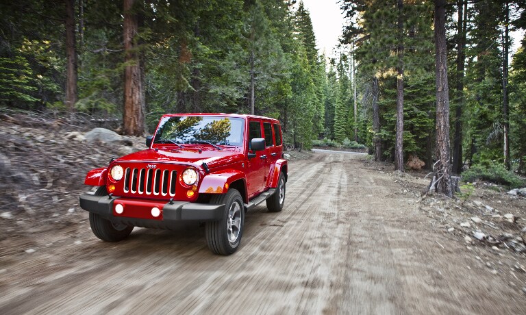 Red 2017 Jeep Wrangler on dirt road Red 2017 Jeep Wrangler