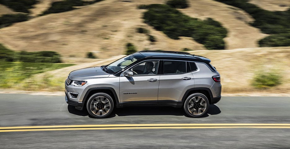 2019 Silver Jeep Compass Limited driving down a road
