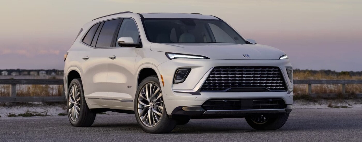 White 2025 Buick Enclave Avenir parked by a fence.