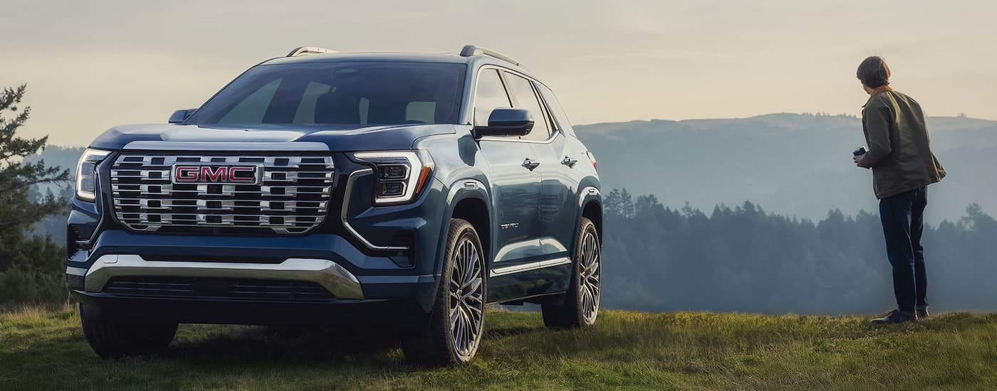 Blue 2026 GMC Terrain Denali parked off-road.