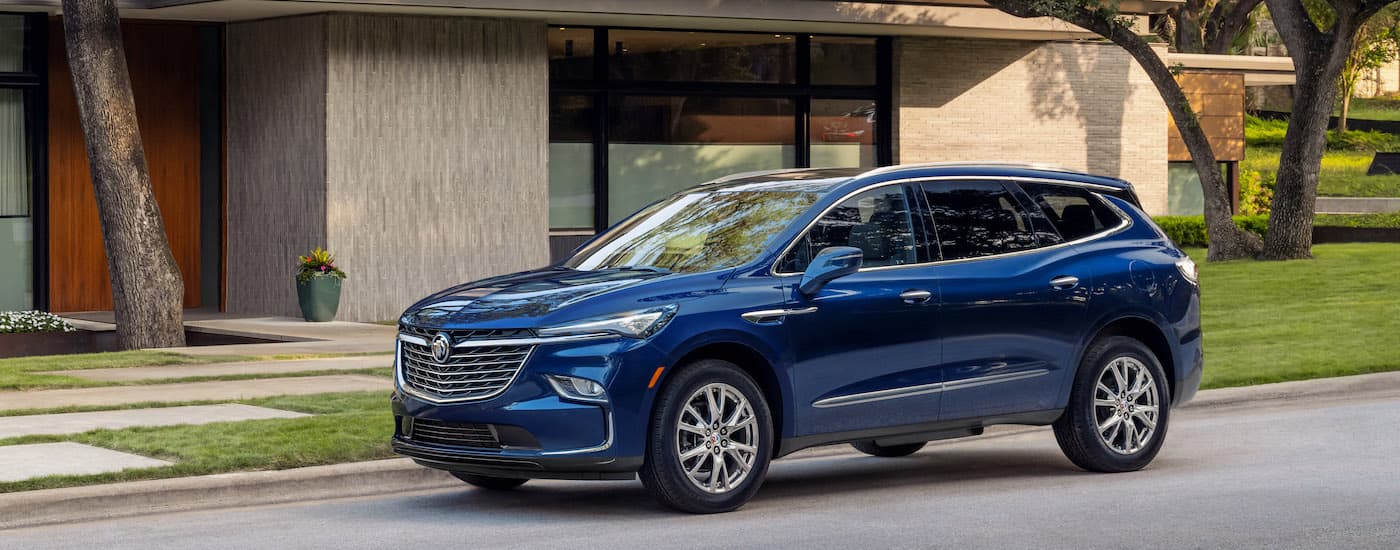 A blue 2025 Buick Enclave from the side after leaving a group of Buick dealers.