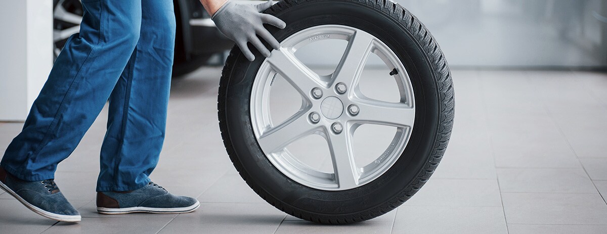 mechanic-holding-a-tire-tire-at-the-repair-garage-2023-11-27-05-16-34-utc.jpg