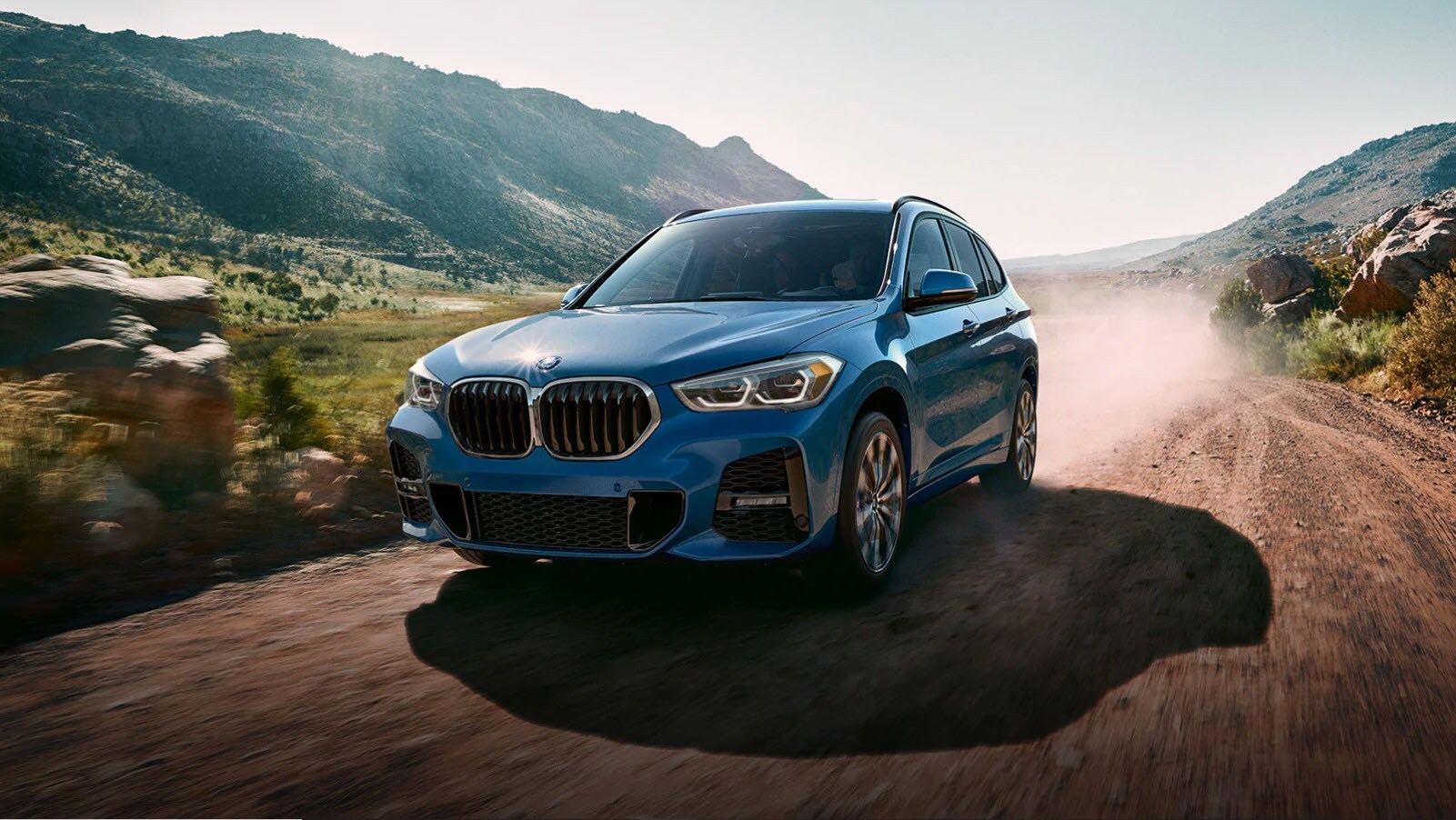 BLUE X1 DRIVING DOWN A DIRT ROAD.jpg