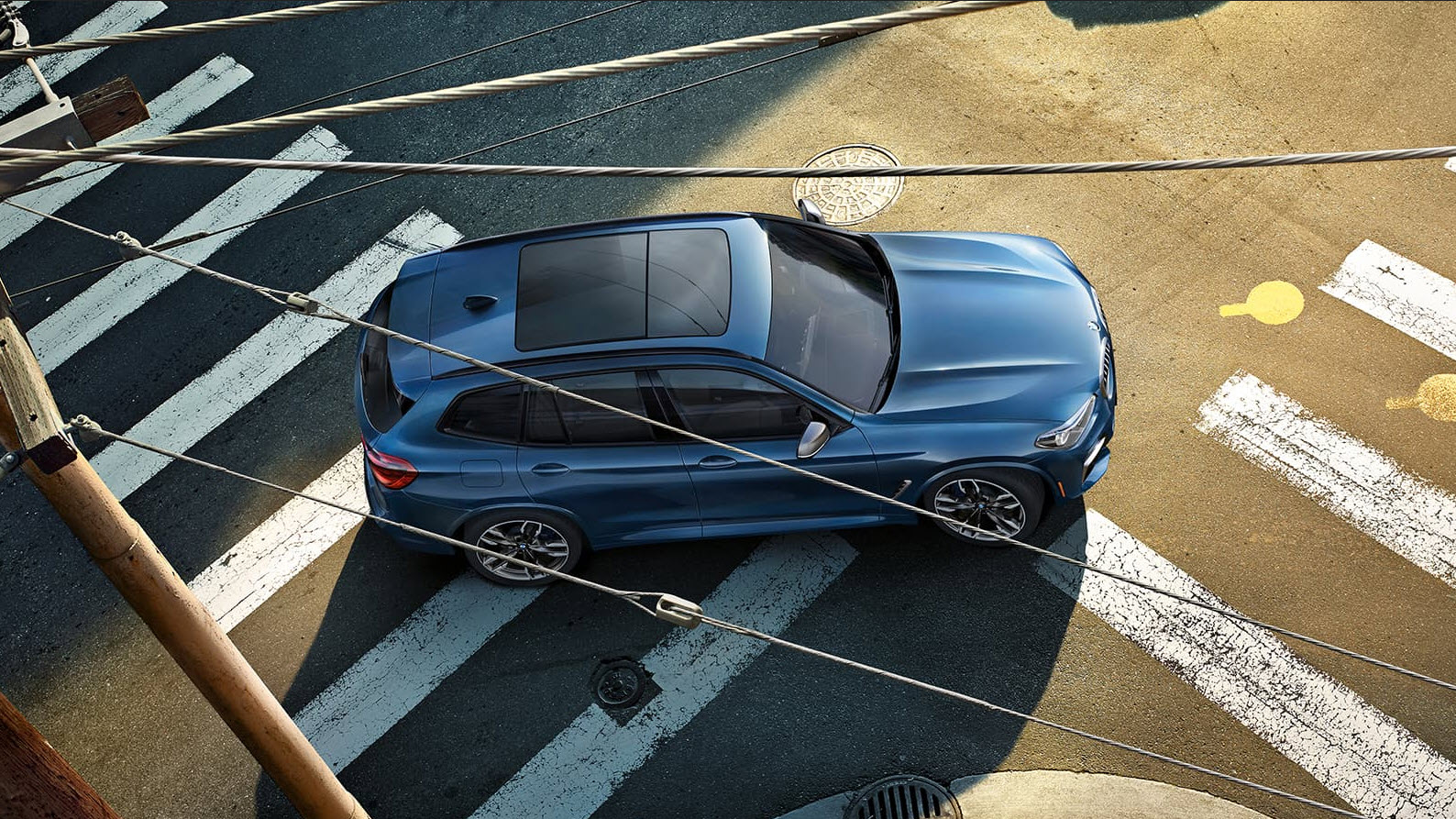 ARIEL VIEW OF A BLUE X3 DRIVING ON A
STREET.jpg