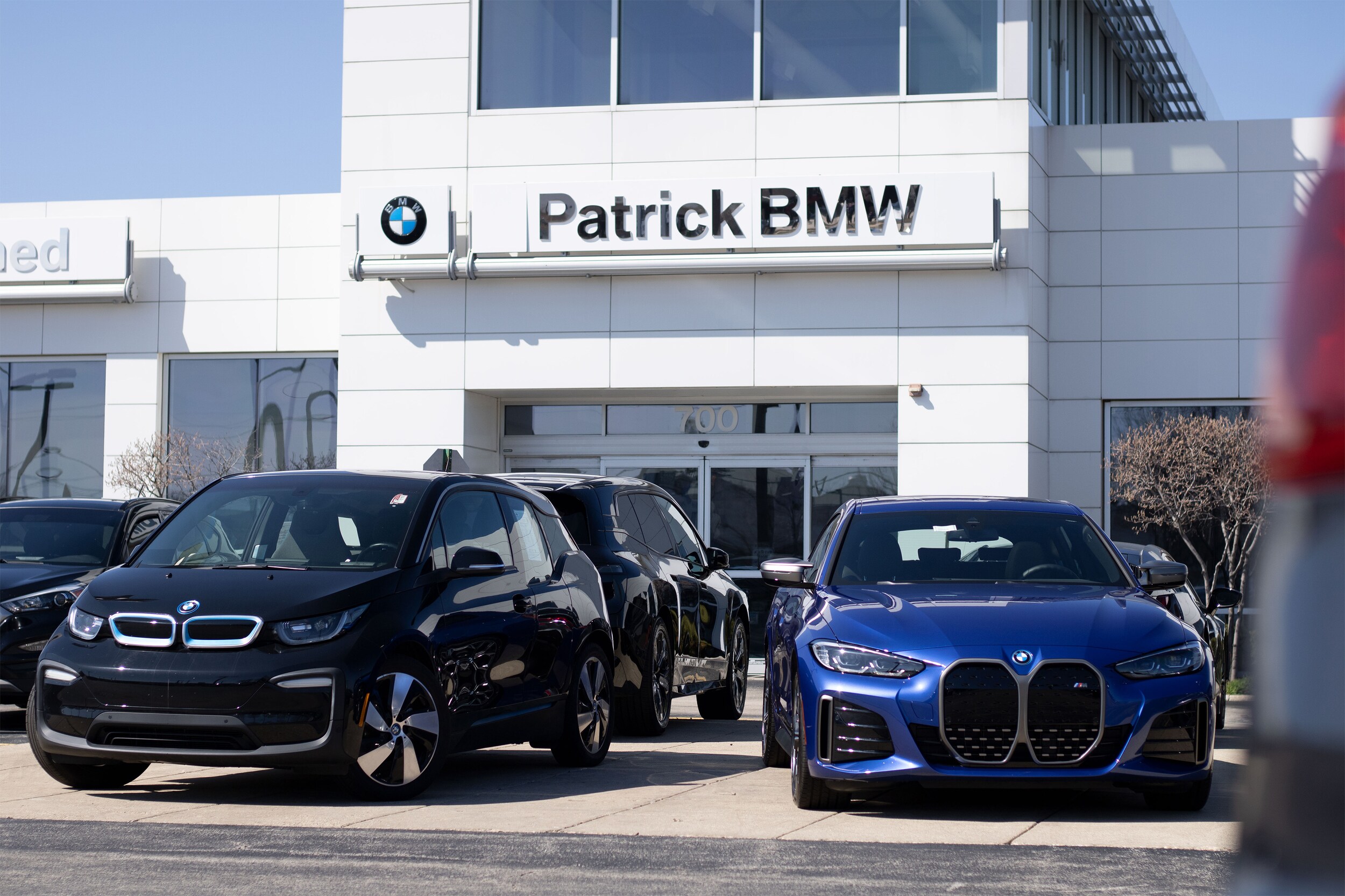 Patrick BMW dealership storefront in Schaumburg, IL, featuring modern architecture and a lineup of new BMW vehicles displayed out front.