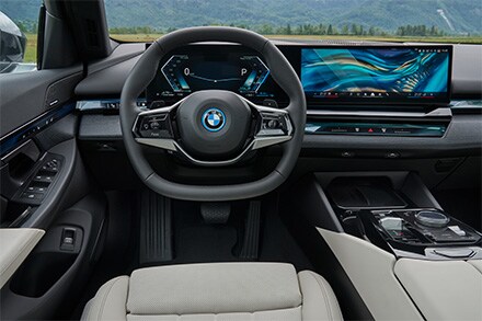 BMW 5 Series parked in an upscale urban setting, showcasing its sleek design and spacious, functional interior.
