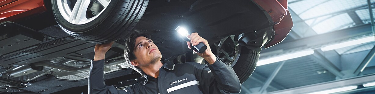 Certified BMW technician performing a precise wheel alignment service on a BMW vehicle at Patrick BMW in Schaumburg, IL.
