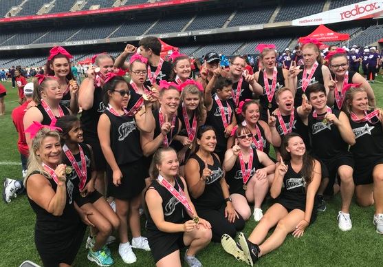 Elite Stars cheer team performing a synchronized routine, showcasing their energy, teamwork, and vibrant uniforms, with a focus on inclusivity and athleticism.