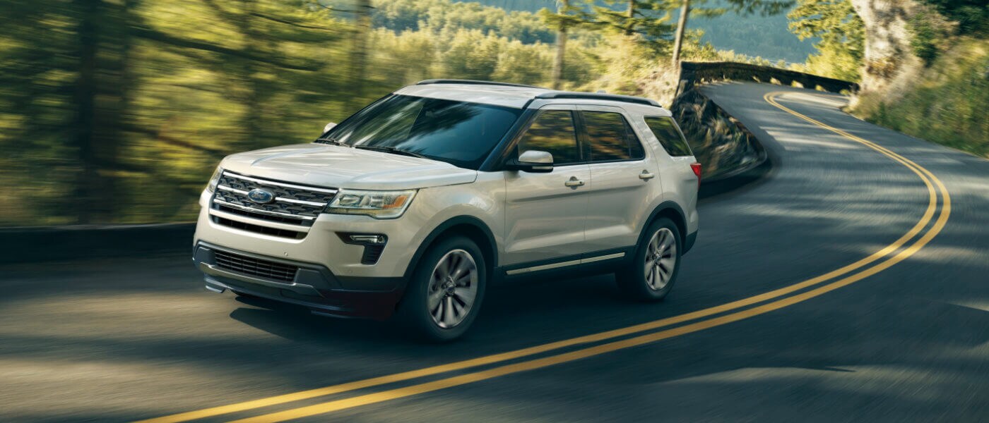 2019 Ford Explorer driving down the road in a forrest