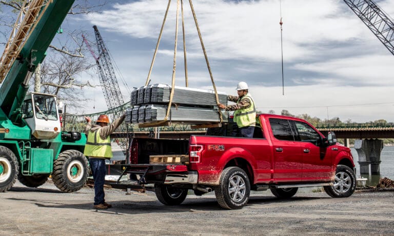 2019 Ford F-150 being loaded with steel beams in construction zone