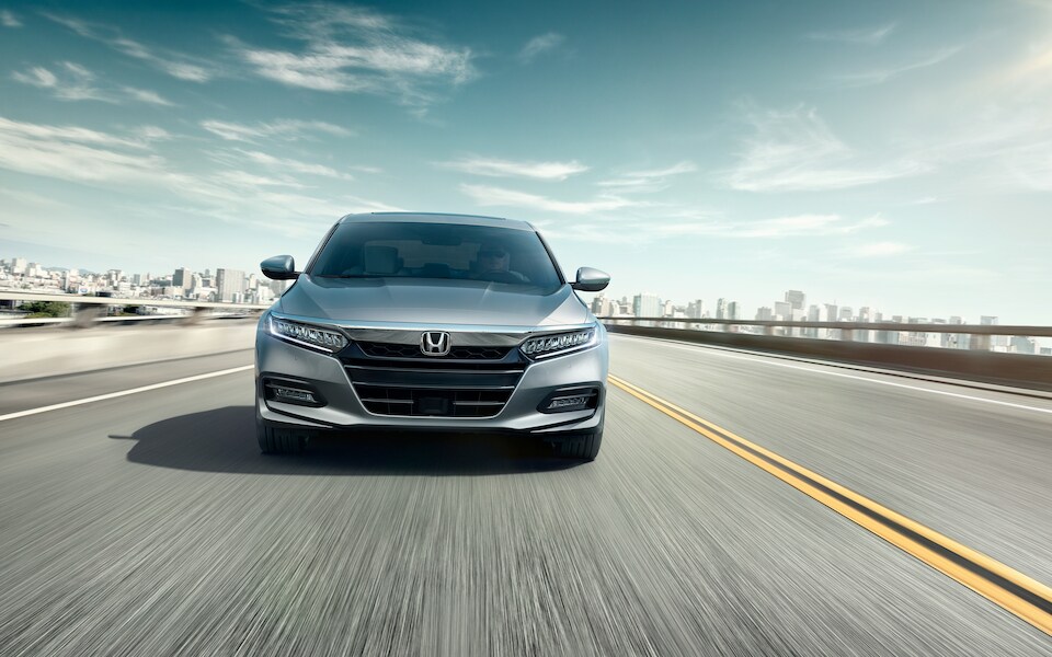 2020 Honda Accord Touring Sedan front view in motion with blue sky and road.jpeg