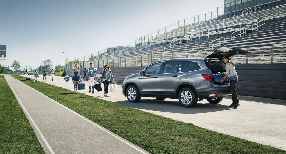 Honda-Lifestyle Man with family loading Honda SUV at football stadium .jpeg