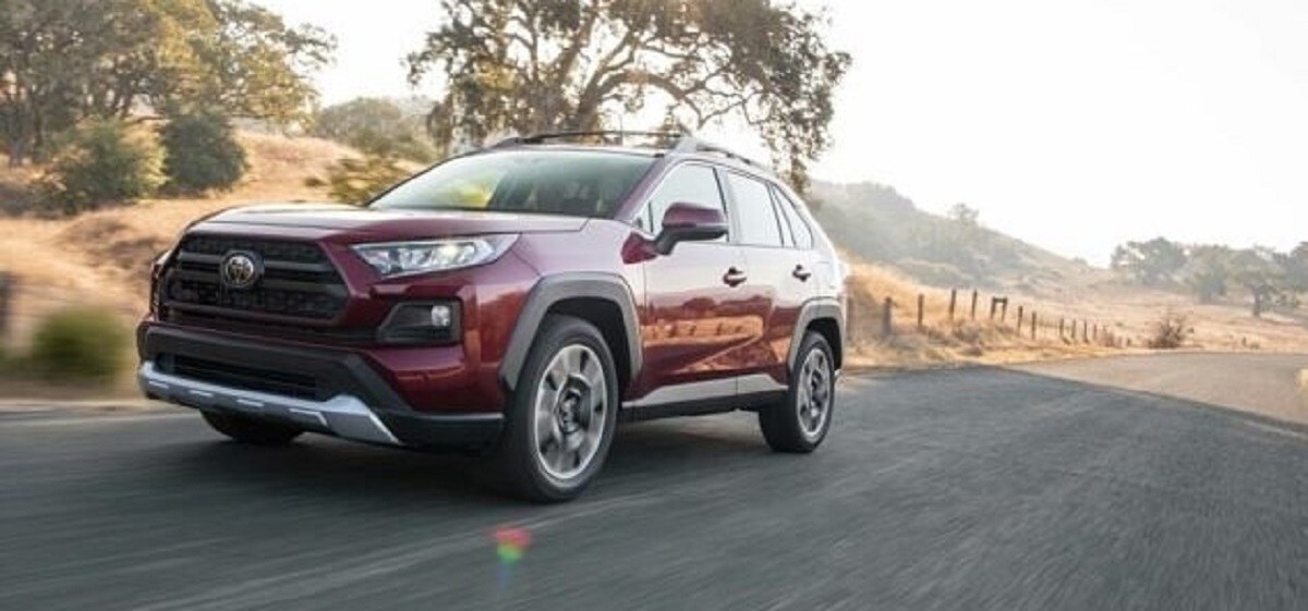 Red Toyota RAV4 driving Front driver side view