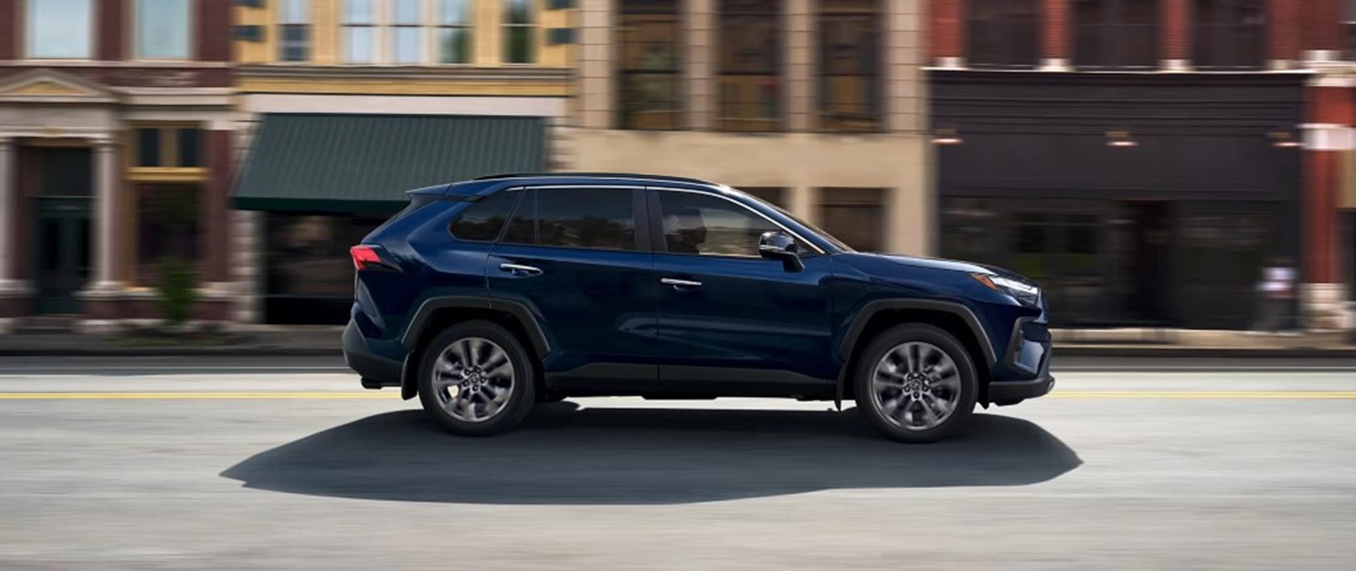 2025 Toyota RAV4 Trim Comparison 2025 Toyota RAV4 driving on a downtown road