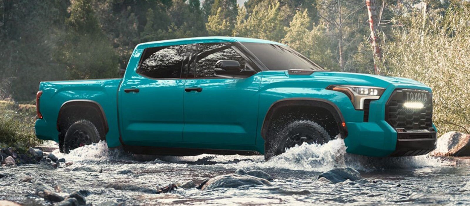 2025 Toyota Tundra Trim Comparison Blue 2025 Toyota Tundra crossing a rushing stream