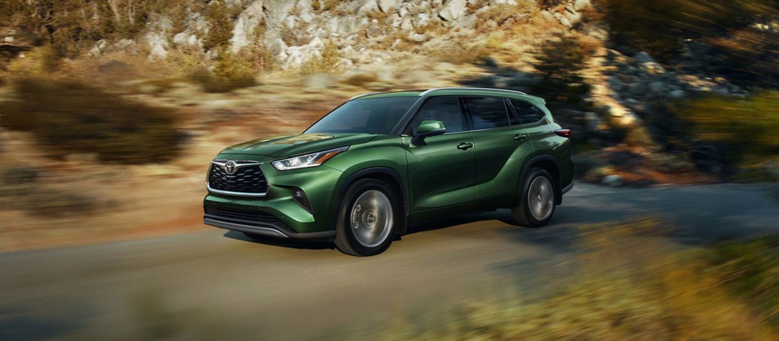 2025 Toyota Highlander Trim Comparison Green 2025 Toyota Highlander drives through a valley