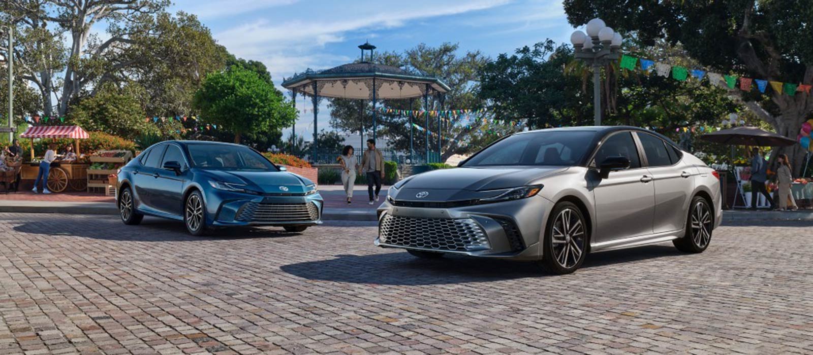 Two 2025 Toyota Camrys parked at a fair 2025 Toyota Camry Trim Comparison