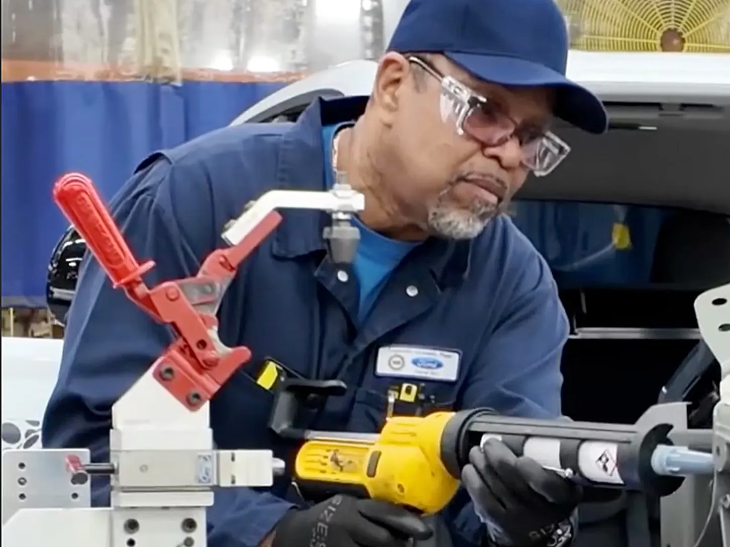 New Ford Fathom Ford technician applying sealant to a car part.