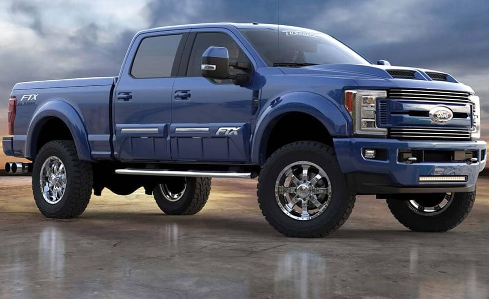 Ford FTX.PNG A bright blue 2022 Ford FTX F-150 with silver rims sits paked on a glossy concrete surface under a stormy-filled sky