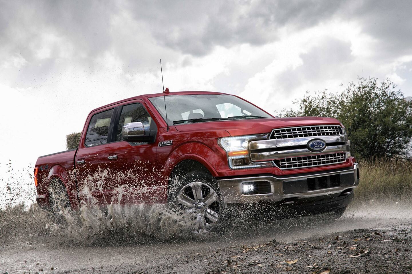 2020-f-150-phil-long-ford-chapel-hills.jpeg A red 2020 Ford F-150 driving through mud and splattering it everywhere