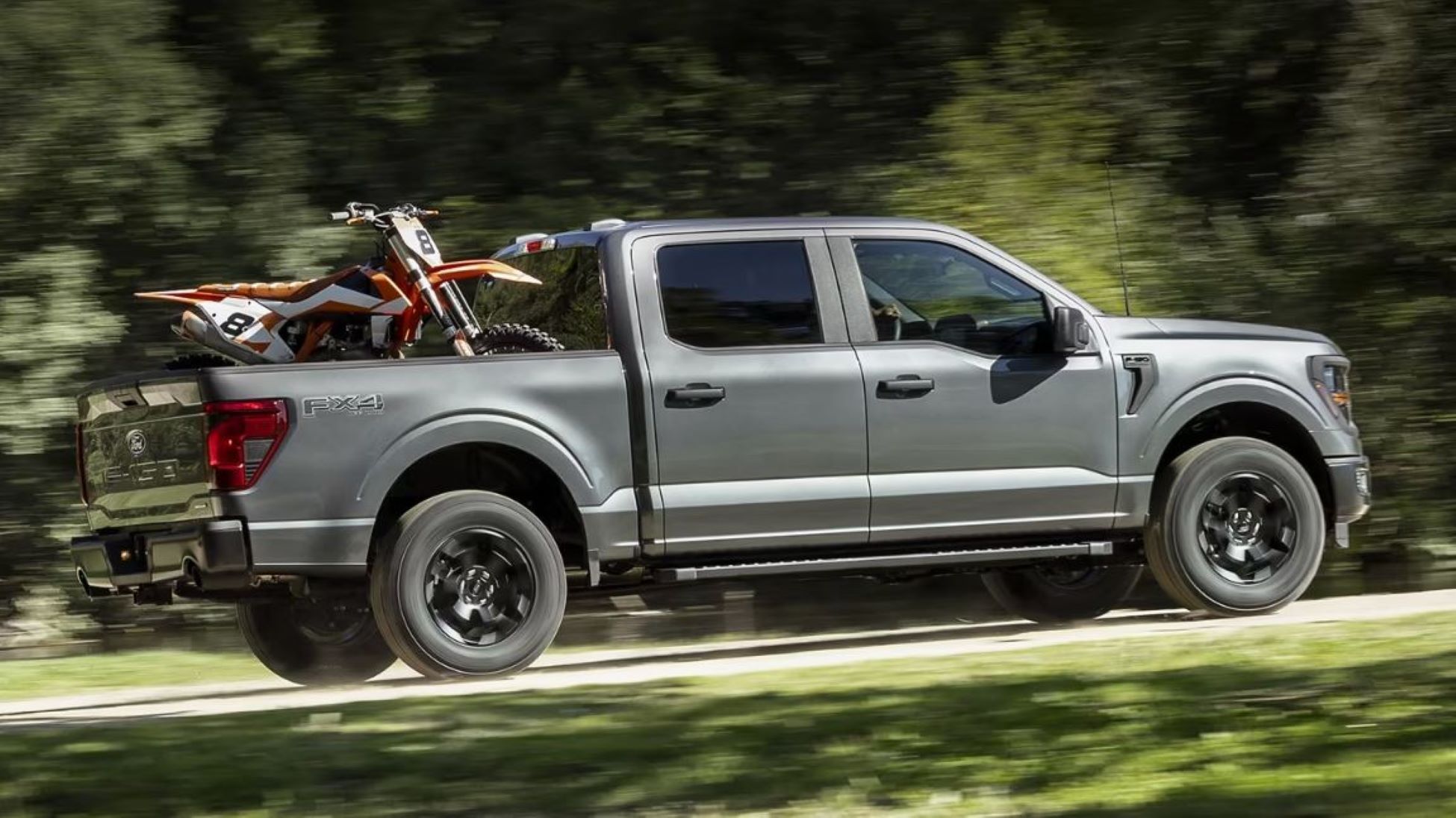 1 F-150 With Dirt Bike in Bed.JPG A Ford F-150 Driving down a road with a dirt bike in the back.