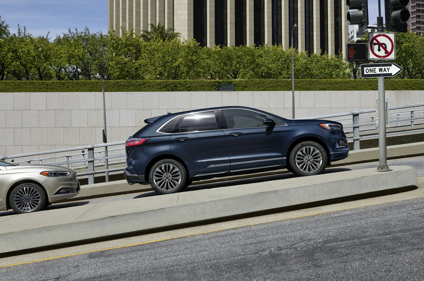 2023-ford-edge-3.PNG A dark blue 2023 Ford Edge sits parked on a city street