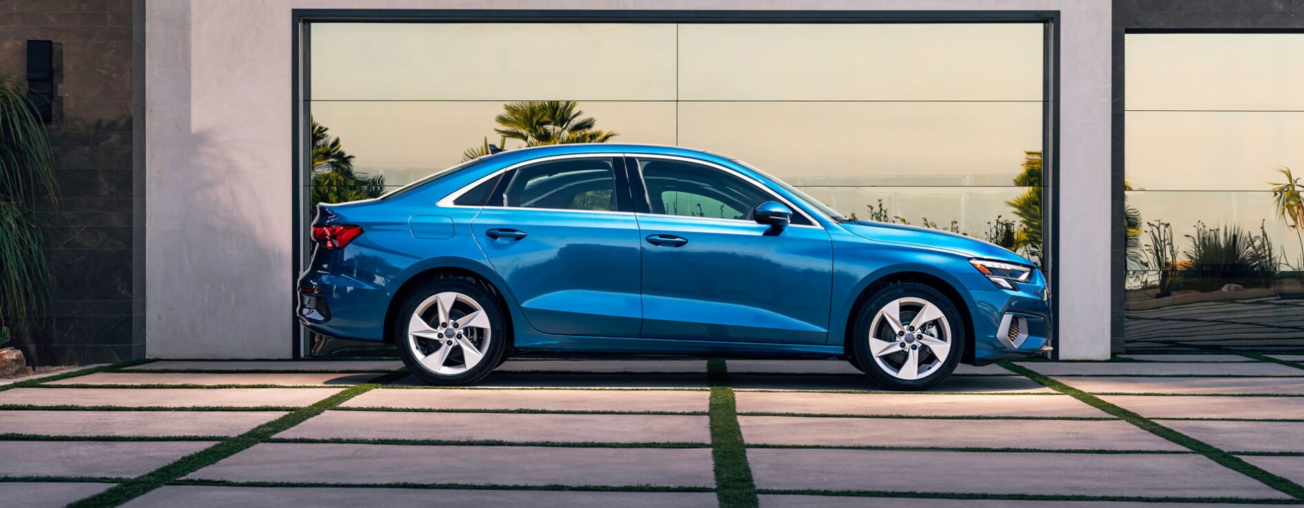 2023-audi-a3-1.PNG a-blue-2023-Audi-a3-sits-parked-on-a-grass-and-concrete-driveway