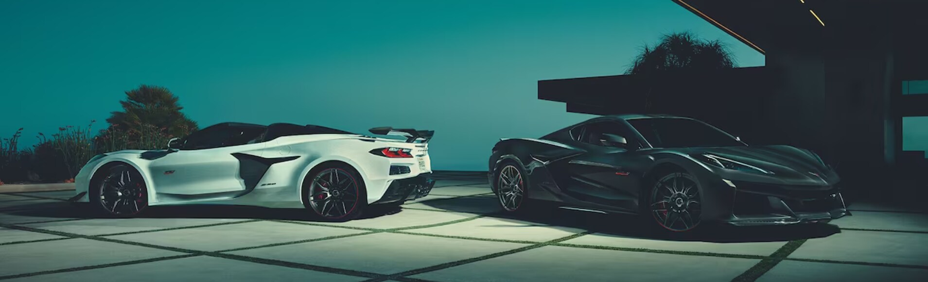 2023-chevy-corvette-6.PNG Two 2023 Chevy Corvettes, one white and one black, are parked next to each other