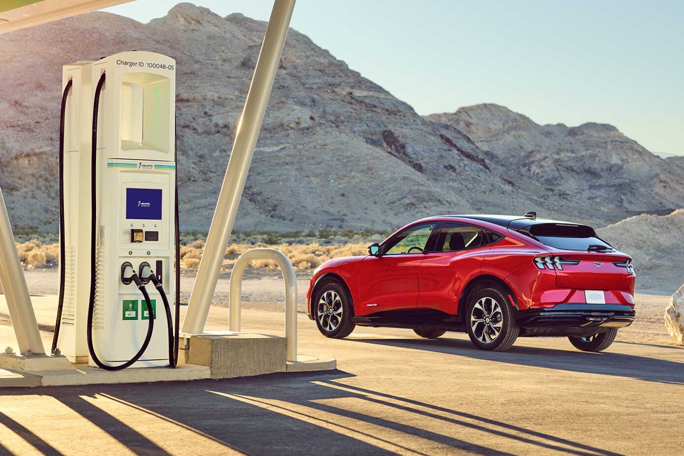 2022-Ford-Mustang-Mach-e.png A red 2022 Ford Mustang Mach-e parked at a charging station in the desert